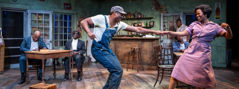 Two people dance in a bar, while the bar's regulars watch.