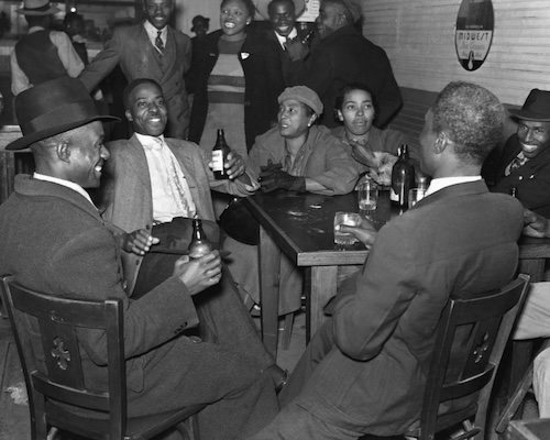 People sitting around a table and drinking beer. They are smiling and the mood is joyous.