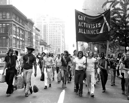 A group of men march arm in arm with a sign reading “Gay Activists Alliance.”