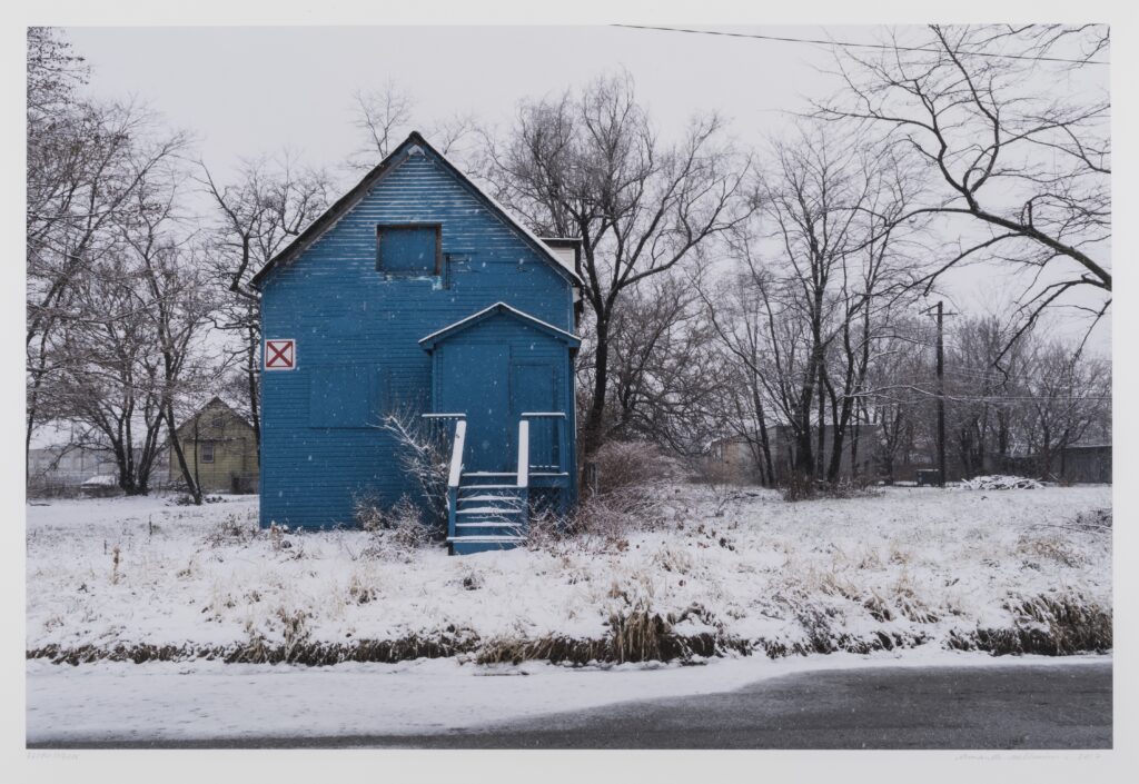 A blue house in a snowy yard.